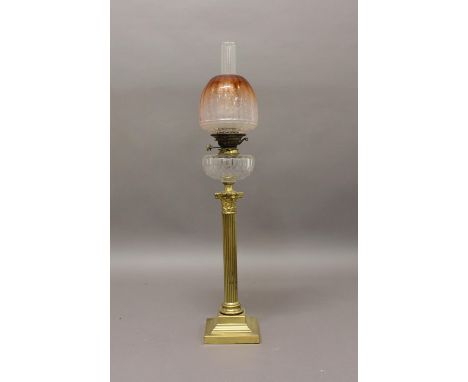 A VICTORIAN OIL LAMP AND SHADE. A Victorian oil lamp on a brass Corinthian column stand with square stepped base, with cut cl