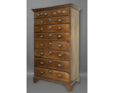 A GEORGE III OAK TALL CHEST OF DRAWERS. The chest with two short and seven long graduated drawers with brass handles and key 