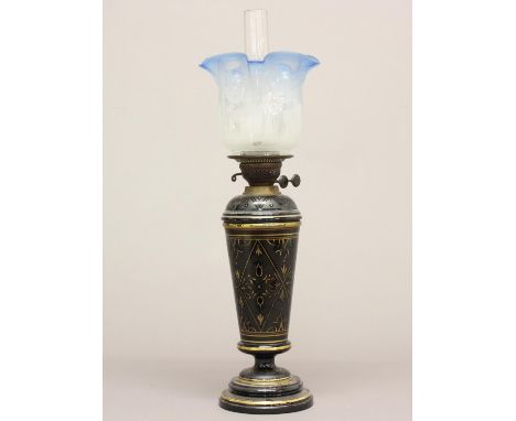 A VICTORIAN OIL LAMP AND SHADE. A Victorian oil lamp with a ceramic base decorated with gilt patterns against a black ground,