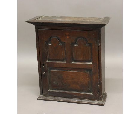AN 18TH CENTURY OAK SPICE CUPBOARD, The door with two arched top and a rectangular fielded panel beneath a broad moulded corn