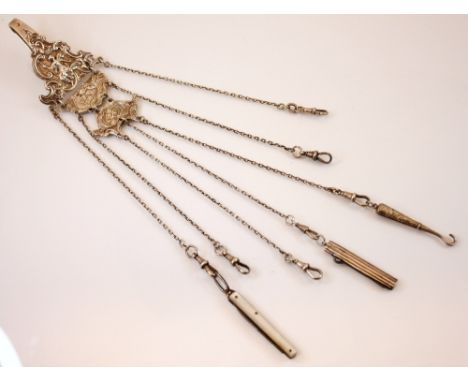 A silver coloured Victorian chatelaine, the clip  depicting a seated lady and scrolling decoration, suspending a silver colou