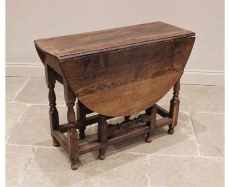 An 18th century oak drop leaf table, the oval top above a single frieze drawer, upon baluster, bobbin and block supports unit