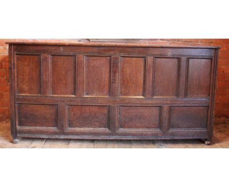 An 18th century oak storage/livery chest, with hinged twin compartments and six recessed panels to the top, over six conformi