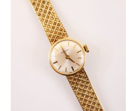 A 9ct gold ladies Garrard wristwatch, the circular cream coloured dial with Arabic numeral and baton markers, 17 jewels movem