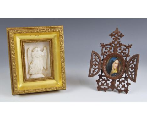 An alabaster relief carved plaque in the Grand Tour manner, modelled as two angels below a star, the gilt frame with indistin