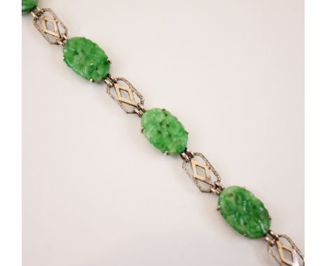 A jade panel bracelet, the five carved jade panels modelled with floral decoration interspersed with white metal lozenge shap