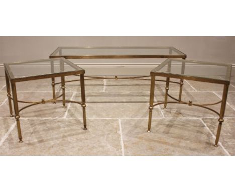 A pair of glass top 'Hollywood Regency' lamp tables, mid 20th century, upon fluted cylindrical brass supports united by a cur