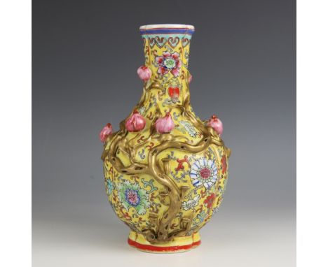 A Chinese porcelain yellow ground Magnolia vase, Qianlong seal mark, the bottle shaped tri-lobed vase applied with magnolia v