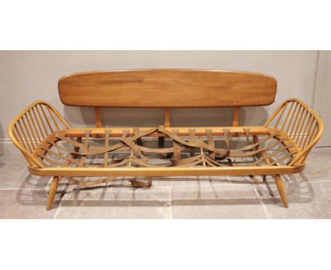 An Ercol honey elm and beech studio couch/day bed, mid 20th century, the detachable back rest extending to curved arm rests, 