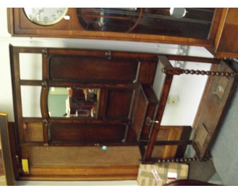 Early 20th century oak hall stand, central bevelled mirror above a single glove drawer flanked by two stick stands, bobbin tu