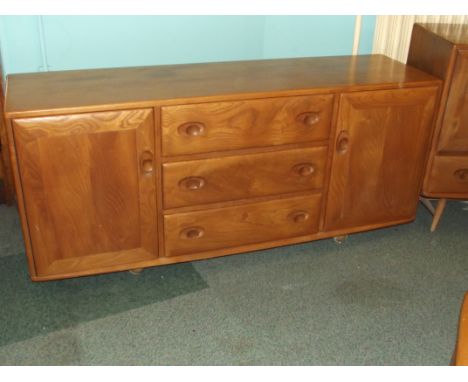 Ercol sideboard in light elm, incorporating three drawers (with cutelry insert) flanked by two cupboards, carried on castors,