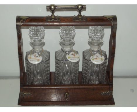 An Edwardian tantalus with  cut glass decanters all with ceramic labels 