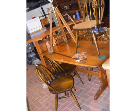 A vintage dark wood Ercol refectory-style dining table, together with four hoop back chairs and a carver