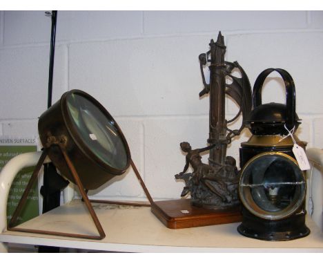 An antique lamp, magnifying glass on stand and bronzed sculpture of ship  