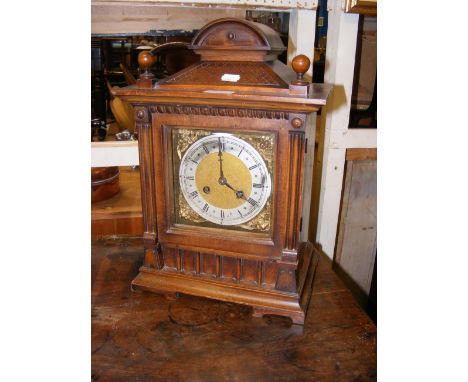 An antique wooden cased striking mantel clock