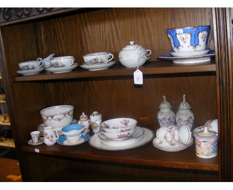 An Oriental tea set together with assorted floral patterned ceramics and a Poole Pottery conserve pot - on two shelves