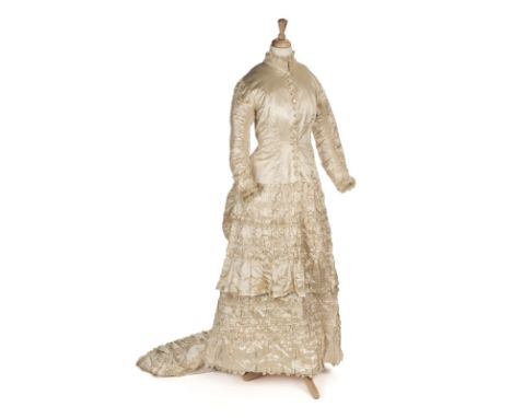 Dress. A cream satin wedding gown with bustled trained skirt, circa 1880s, handmade dress, with boned fitted bodice, front op