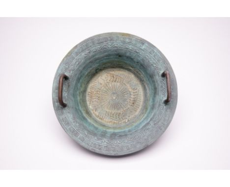 A CHINESE TWIN HANDLED METALWARE BASIN
With brass handles, decorated with four koi fish and ying and yang symbol to the centr