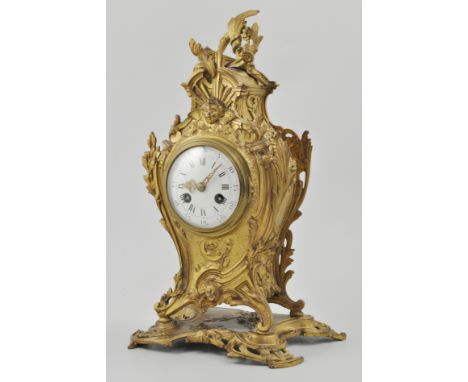 French gilt metal rococo style mantel clock, scrolled casing, white enamel dial, with Arabic and Roman numerals, cylinder mov