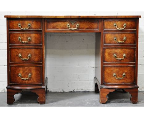 Reproduction walnut twin pedestal desk, triple bowfront with a tooled leather inset, fitted with a central drawer and four dr