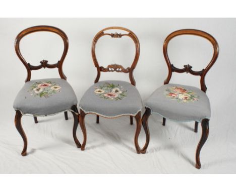 A set of four Victorian walnut balloon back dining chairs with floral tapestry seats and a pair of similar chairs upholstered