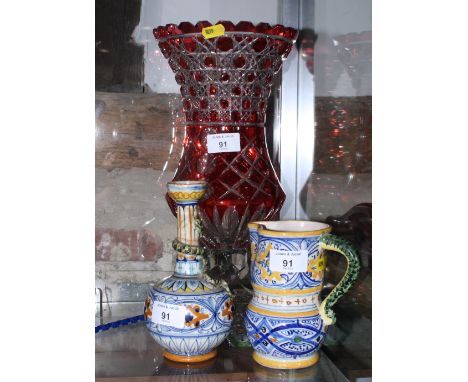 A ruby flashed crystal pedestal flower vase, 14" high, a Cantagalli bottle-shaped vase, 5" high, and a majolica decorated jug