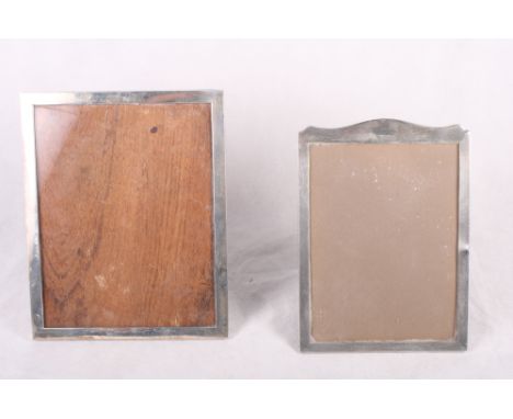 An engine turned silver photograph frame, 9" x 6 1/2", and two larger photograph frames, stamped "STERLING"