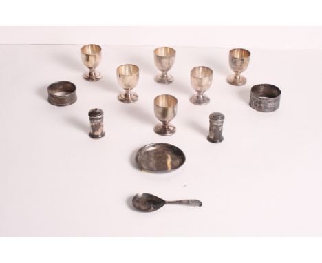 Six miniature silver goblets, two silver napkin rings, a silver dish, a silver caddy spoon and a pair of silver condiments, 5