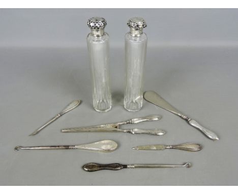 Pair of silver topped glass vanity bottles, together with six antique silver handled vanity items including glove stretchers,