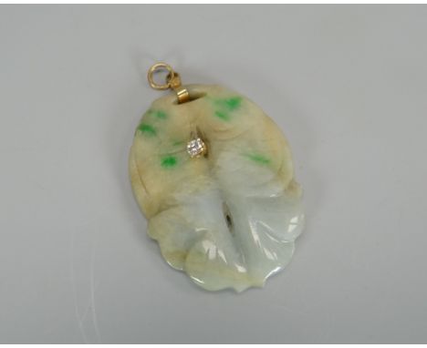 A CARVED JADE PENDANT WITH DIAMOND SOLITAIRE