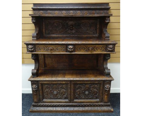 A NINETEENTH CENTURY CONTINENTAL CARVED BUFFET SIDEBOARD heavily carved with floral motifs, grotesque masks and nature, the b