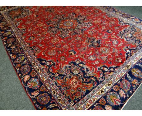 A RED GROUND PERSIAN MARSHAD CARPET with traditional medallion design, 350 x 256cms