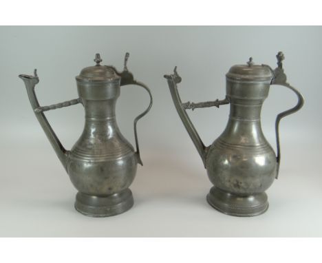 A NEAR PAIR OF MID-EIGHTEENTH CENTURY SWISS PEWTER 'STEGKANNE' JUGS of footed form with bulbous bodies narrowing to the neck,