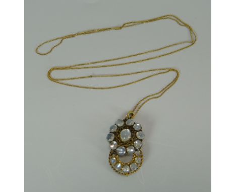 A VICTORIAN MOONSTONE PENDANT in the form of connected crescent and circle, in believed gold setting on a fine gold necklace 
