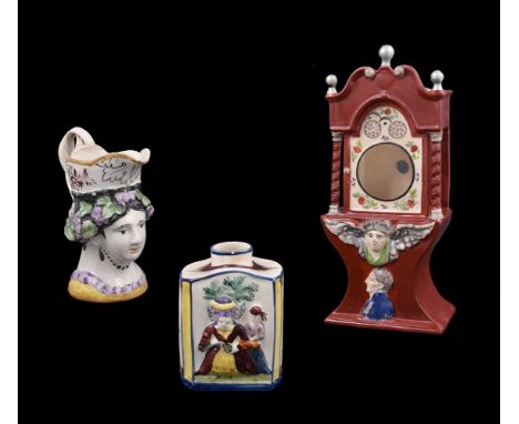 A Staffordshire pearlware watcholder, circa 1820, modelled as a longcase clock hood, 24.5cm high; and two later Leeds Pottery