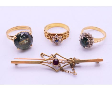 Three 18 K gold rings (13 grammes total weight) and a 15 ct gold bar brooch (3.8 grammes total weight). The latter 6 cm wide.