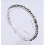 A colour-treated diamond bracelet designed as a brilliant-cut colour-treated "green" diamond line,