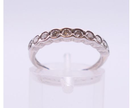 An unmarked white gold ten-stone diamond ring. Ring size K/L. 