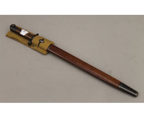An early 20th century bayonet in scabbard. 57 cm long.
