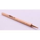 A 9 ct gold extending ruler pencil. 33 cm long extended. 25.7 grammes total weight.