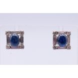 A pair of sapphire and diamond earrings, each of square outline, the oval sapphire cabochon,