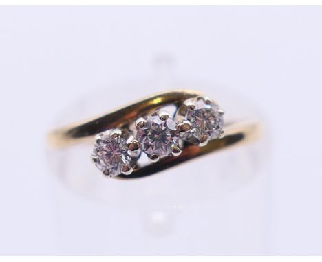 A 9 ct gold three-stone diamond ring. Ring size J/K. 