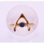 An 18 ct gold and sapphire wishbone ring. Ring size E. 1.7 grammes total weight.