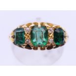 An 18 ct gold emerald and diamond ring. Ring size R.