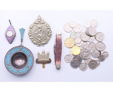 A silver and enamel tea strainer, a silver and enamel watch, coins, cap badges, etc. The former 12 cm long. 