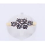 An 18 ct gold six-stone diamond ring. Ring size N.