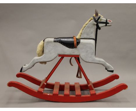 A vintage painted wooden rocking horse. 106 cm long.