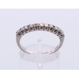 An 18 ct white gold eleven-stone diamond ring. Ring size Q.