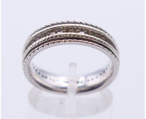An 18 K white gold eternity ring. Ring size O. 