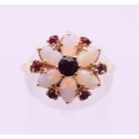 A 9 ct gold opal and garnet flowerhead ring. Ring size N/O.